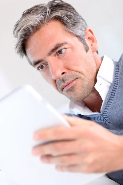 40-year-old man στο σπίτι χρησιμοποιώντας ηλεκτρονικό, ταμπλετών — Φωτογραφία Αρχείου