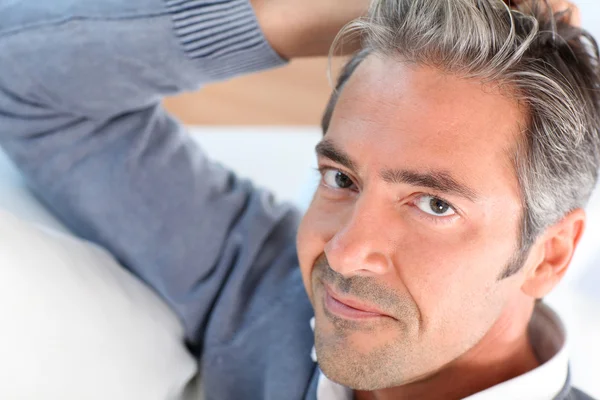 Bonito homem relaxando no sofá em casa — Fotografia de Stock