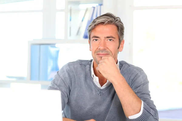 Mann sitzt im Büro vor Laptop — Stockfoto