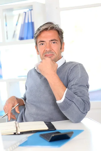 Hombre sentado en su escritorio en la oficina — Foto de Stock