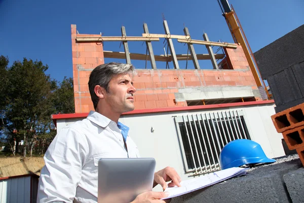 Unternehmer prüft Plan auf Baustelle — Stockfoto