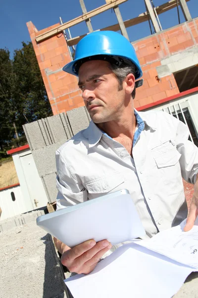 Entrepreneur checking plan on construction site — Stock Photo, Image
