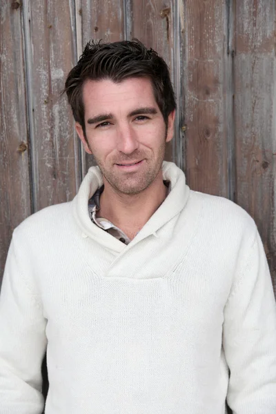 Retrato de un hombre guapo de pie en la puerta de madera — Foto de Stock