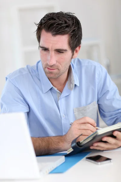 Office worker writing on agenda — Stock Photo, Image