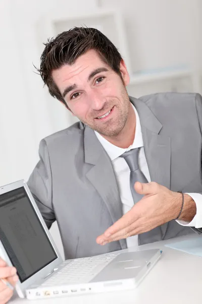 Empresario mostrando algo en el ordenador portátil — Foto de Stock