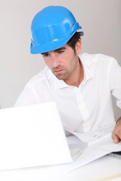 Bauleiter mit Schutzhelm im Büro — Stockfoto