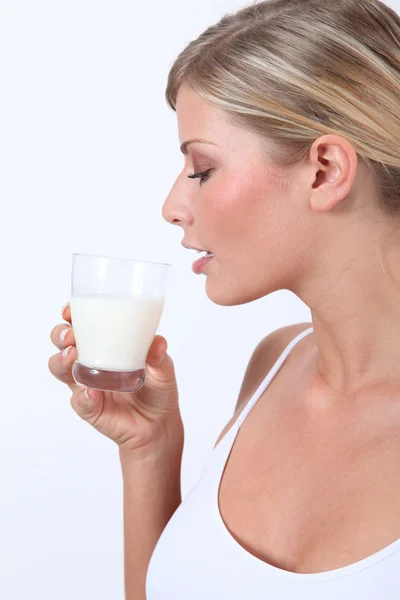 Beautiful blond woman holding glass of milk Stock Photo