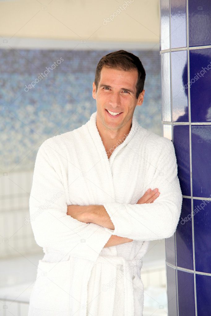Man with bathrobe standing by spa pool