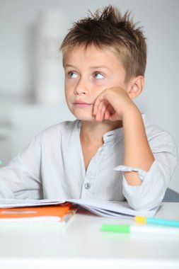 Küçük çocuk ödevini yapıyor.