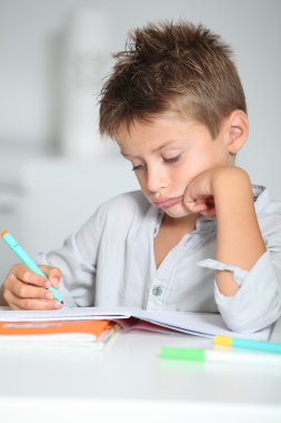 Küçük çocuk ödevini yapıyor.