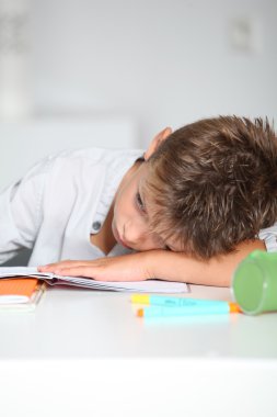 Küçük çocuk ödevini yapıyor.