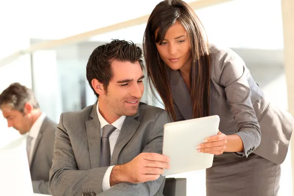 Equipe de negócios usando tablet eletrônico no trabalho — Fotografia de Stock