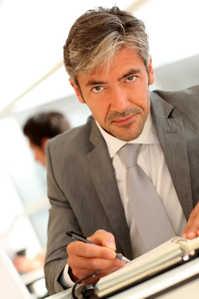 Handsome executive sitting at desk in office — Stock Photo, Image