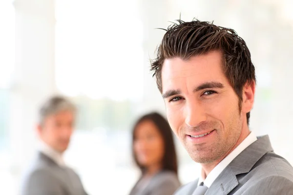 Portret uśmiechający się biznesmen stoi w hali — Zdjęcie stockowe