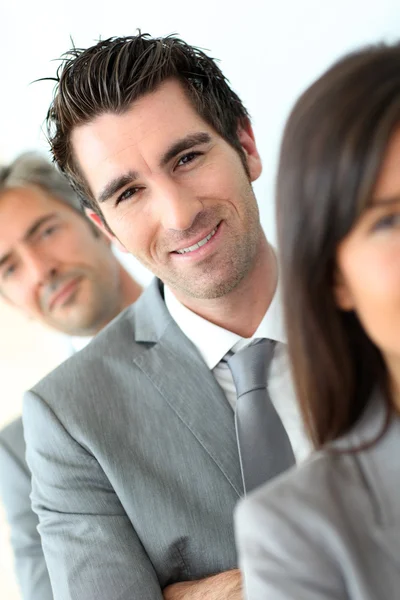 Empresário sorridente entre grupo — Fotografia de Stock