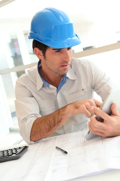 Arquiteto sorridente no escritório trabalhando com tablet eletrônico — Fotografia de Stock