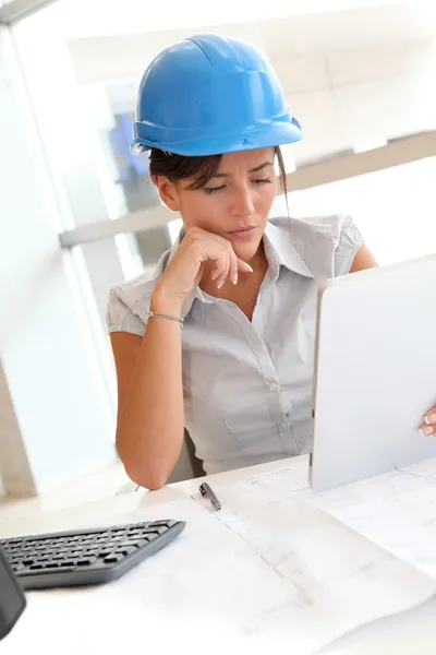 Lachende vrouw architect in kantoor werken met elektronische tablet — Stockfoto