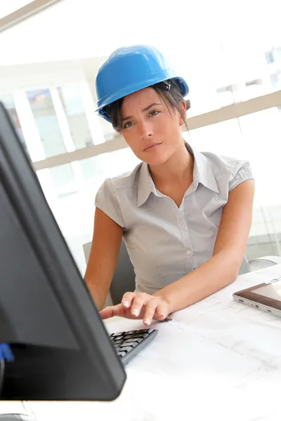 Lachende vrouw architect in kantoor werken op desktop computer — Stockfoto