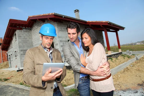 Unternehmer zeigt Paar im Bau befindliches Haus — Stockfoto