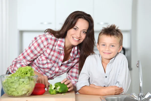 Mother cooking with son in kitchen — Stock Photo, Image