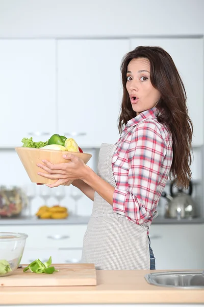 Schöne Frau stakst in Küche mit Schürze — Stockfoto