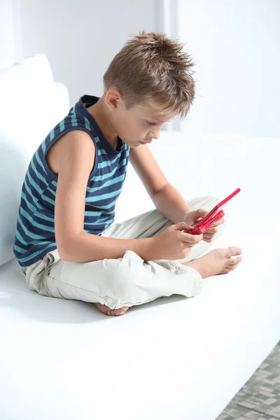 Little boy playing video games on sofa — Stock Photo, Image