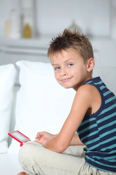 Niño jugando videojuegos en el sofá — Foto de Stock