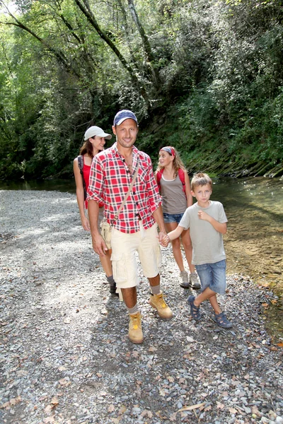 Familia cruzando un río — Foto de Stock