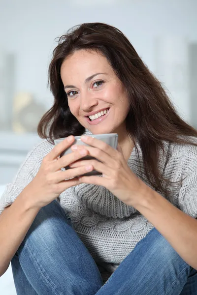 Primo piano di bella donna con bevanda calda a casa — Foto Stock