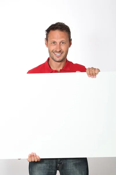 Homem de camisa vermelha mostrando placa branca — Fotografia de Stock