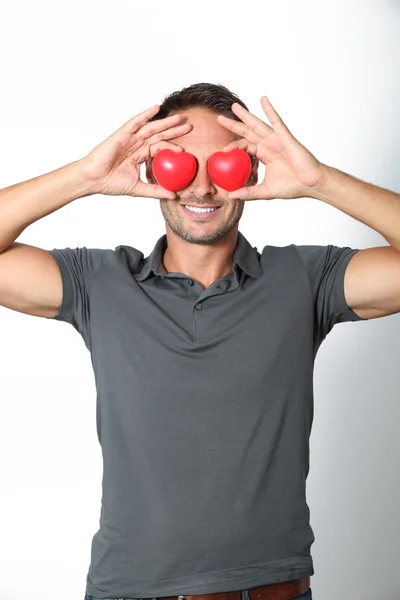 Man covering his eyes with 2 hearts — Stock Photo, Image