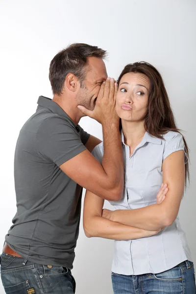Uomo sussurrando alla sua ragazza orecchio — Foto Stock