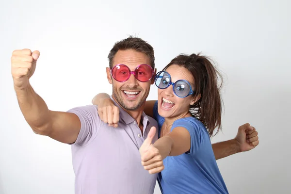 Casal usando óculos coloridos se divertindo — Fotografia de Stock