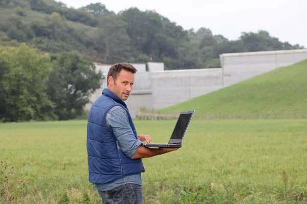 Engineer standing in front of dam under construction — Stock Photo, Image