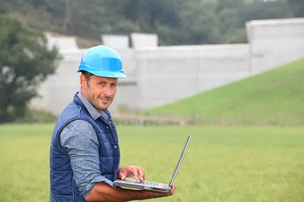 Engenheiro em pé em frente à barragem em construção — Fotografia de Stock