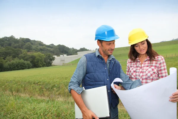 Business checking plan on construction site — Stock Photo, Image