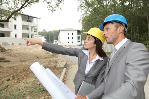 Equipe de arquitetos verificando planos no local — Fotografia de Stock