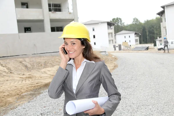 Empresário com capacete verificando local em construção — Fotografia de Stock