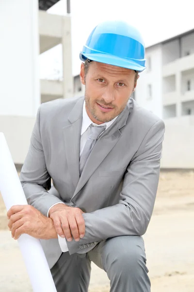 Empresário com capacete verificando local em construção — Fotografia de Stock