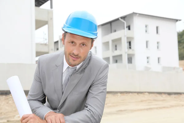 Uomo d'affari con casco sito di controllo in costruzione — Foto Stock