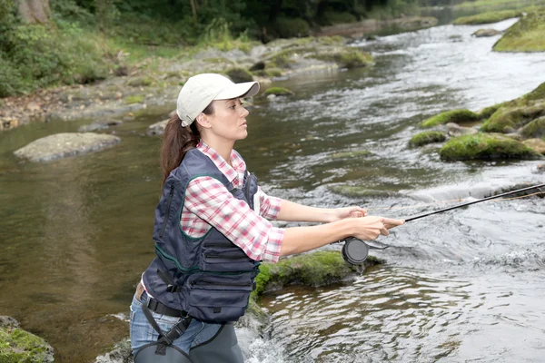 Donna con canna da pesca a mosca nel fiume — Foto Stock