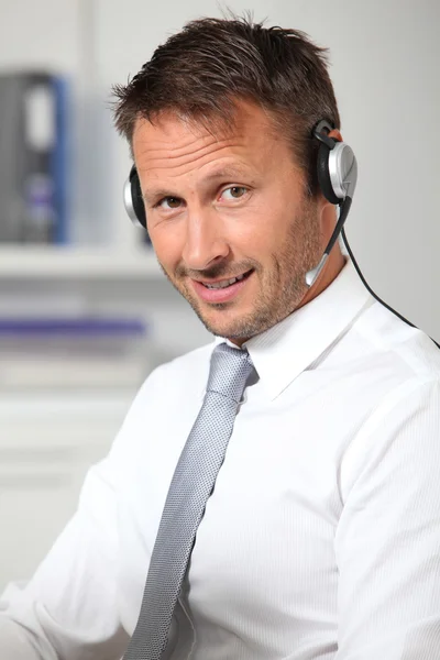Closeup επιχειρηματίας στο γραφείο με ακουστικά — Φωτογραφία Αρχείου