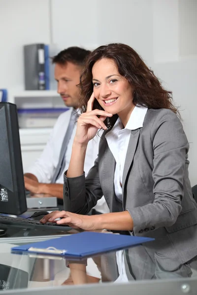 Mulher bonita digitando na mesa do computador — Fotografia de Stock