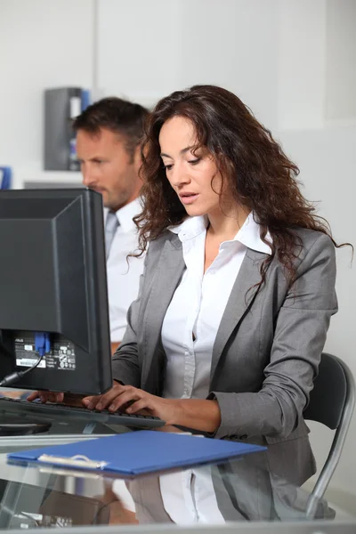 Mujer hermosa escribiendo en el escritorio de la computadora — Foto de Stock