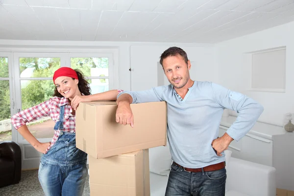 Casal segurando caixas em sua nova casa — Fotografia de Stock