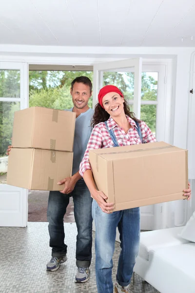 Casal segurando caixas em sua nova casa — Fotografia de Stock