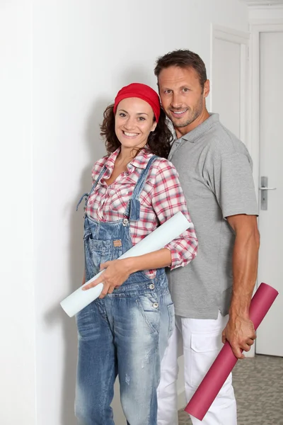 Casal de pé em sua casa com rolos de papelão — Fotografia de Stock