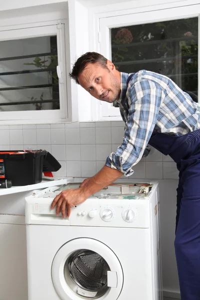 Plumber fixing broken washing machine — Stock Photo, Image