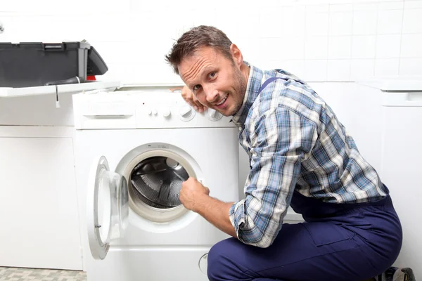 Plumber fixing broken washing machine — Stock Photo, Image