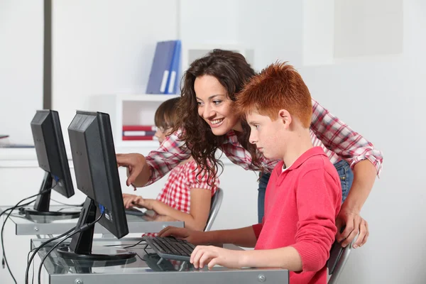 Insegnante e bambini che imparano a usare il computer — Foto Stock